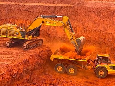 Excavator loading a truck on a bulk earthworks cut