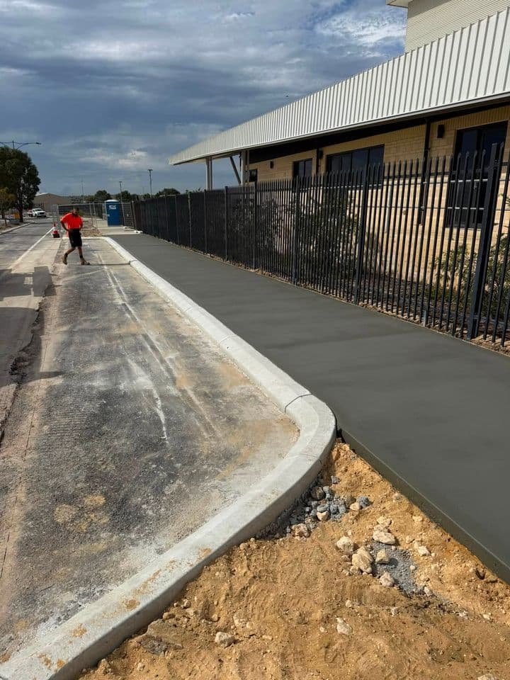New concrete kerb and footpath poured beside a commercial building