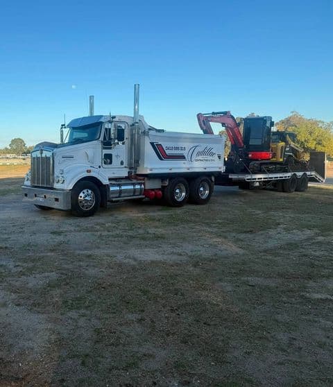 Kenworth tipper truck and float carrying an excavator and skid steer
